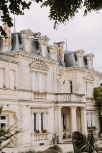 a large white building with a lot of windows at le petit château de Célestine in Segonzac