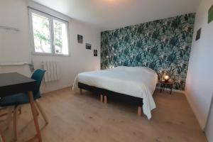 une chambre avec un lit et une peinture murale dans l'établissement Villa 4 personnes - 5 minutes mer - plein sud à trevou-treguignec pres de perro, à Trévou-Tréguignec