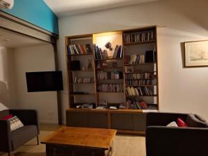 un salon avec une étagère remplie de livres dans l'établissement Villa 4 personnes - 5 minutes mer - plein sud à trevou-treguignec pres de perro, à Trévou-Tréguignec