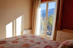 a bedroom with a bed and a window with a view at La myrtillette in Luchon