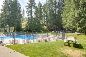 RathdrumにあるTwin Lakes Retreat Lake and Golf Access!の芝生にベンチがあるプールの周りのフェンス