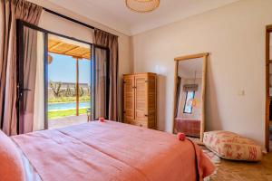a bedroom with a large bed and a large window at Villa Yakout in Ghazoua +48 photos