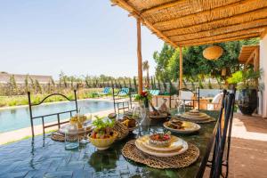 a table with food on it on a patio at Villa Yakout in Ghazoua