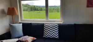 a couch with pillows sitting in front of a window at Lilla Villa Svanö in Lunde +10 photos