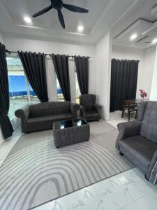 a living room with two couches and a ceiling fan at D Aur Poolvilla Seaview in Bachok
