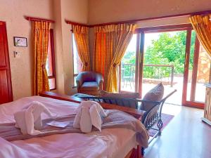 Un dormitorio con dos camas y una gran ventana. en La Montagne Guest Lodge, en Hartbeespoort