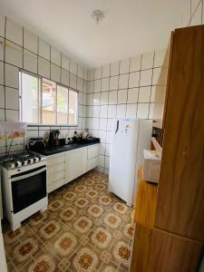 a kitchen with a stove and a white refrigerator at Casa la Bohème in Serra +12 photos