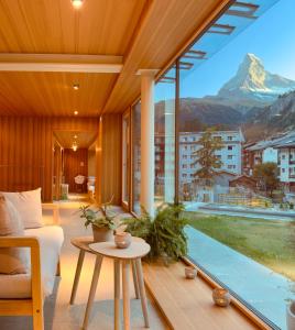 a living room with a view of a mountain at Hotel Capricorn in Zermatt