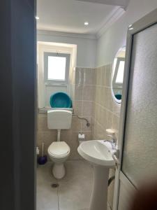 a small bathroom with a toilet and a sink at Bluva rooms Himare in Himare