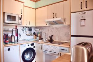 a kitchen with a washing machine and a microwave at Villa Zen in Majanicho