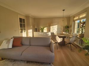 a living room with a couch and a table at Luxe vakantiehuis op de Veluwe met tuin in Barneveld in Barneveld