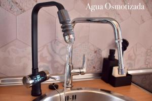 a kitchen sink with a running water faucet at Villa Zen in Majanicho +12 photos