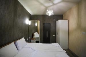 ein Schlafzimmer mit einem großen weißen Bett und einem Spiegel in der Unterkunft Khaz Cottage Dilijan in Dilidschan