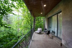 ein Balkon eines Hauses im Wald in der Unterkunft Khaz Cottage Dilijan in Dilidschan