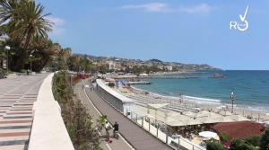 a view of a beach with people and the ocean at Hotel Washington in Sanremo