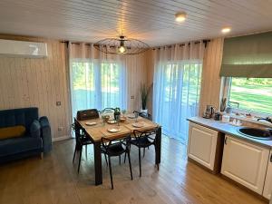 a kitchen with a table and chairs in a room at Viesu māja Silapurenes in Mērsrags