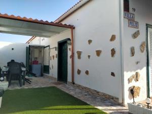 ein weißes Haus mit einer Terrasse mit grünem Rasen in der Unterkunft Villa Feliz in Abades