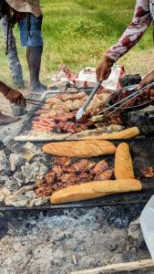 a group of people cooking food on a grill at Poisson D'or Guest House in Saint Francois
