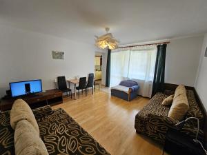 a living room with a couch and a dining room at Przytulny - blisko centrum in Suwałki