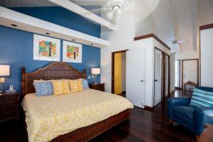 a bedroom with a bed and a blue wall at Hideaway Villa 2 Minute walk to Gracebay beach in The Bight Settlements