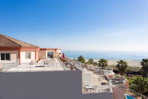 a view of the beach from the balcony of a house at Grand Hôtel Les Flamants Roses Thalasso & Spa in Canet-en-Roussillon