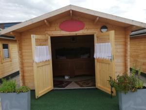 a large wooden dog house with a red frisbee at AlmOtel - Auf der HerziAlm 