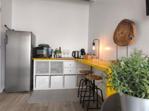 a kitchen with a refrigerator and a counter with stools at Ritual do Mar - Quarto com WC - Baleal & Peniche in Ferrel