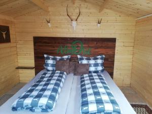 a bedroom with a bed in a log cabin at AlmOtel - Auf der HerziAlm 