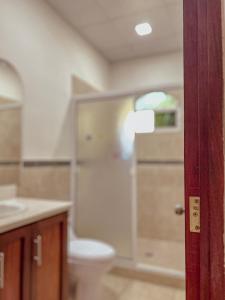 a bathroom with a toilet and a sink at Escapada a Perla de Mar - ATAMI in Tamanique
