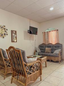 a living room with two chairs and a couch at Escapada a Perla de Mar - ATAMI in Tamanique +14 photos