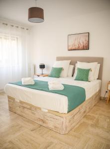 a bedroom with a large wooden bed with green pillows at Le Ligure 3P Port de Nice Climatisation et Parking in Nice