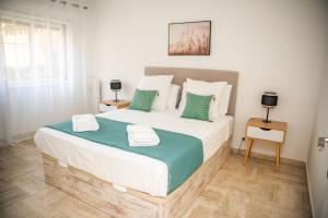 a bedroom with a large bed with green and white pillows at Le Ligure 3P Port de Nice Climatisation et Parking in Nice