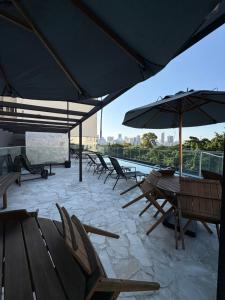 a group of chairs and tables with umbrellas on a roof at Conforto e aconchego na Glória- Rio de Janeiro in Rio de Janeiro