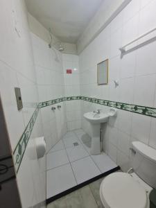 a white bathroom with a toilet and a sink at Hostal La Extincion in Torotoro +19 photos
