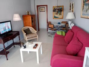 a living room with a pink couch and a piano at Noja 1 in Noja