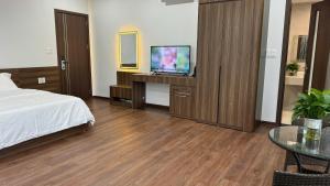 a bedroom with a bed and a tv and a table at Happy Ocean View Villa in Tài Xá