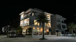 a large white building with a palm tree in front of it at Happy Ocean View Villa in Tài Xá