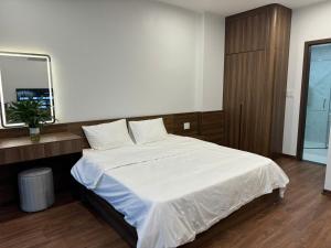 a bedroom with a white bed and a mirror at Happy Ocean View Villa in Tài Xá +2 photos