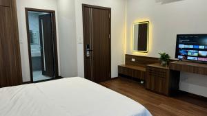 a bedroom with a large bed and a television at Happy Ocean View Villa in Tài Xá