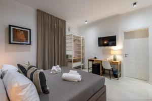 a bedroom with a bed and a desk in it at Hotel Vicolo Aperta in Trapani
