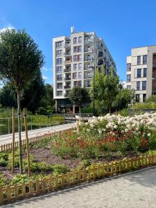 a garden with flowers in front of a building at Tuyo Apartments Lake park in Warsaw