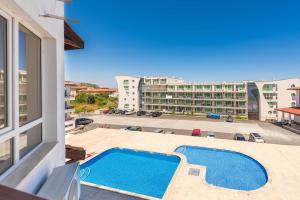 Una vista de la piscina desde el balcón de un edificio. en Апартамент Danili нов двустаен апартамент с басейн и паркомясто в гр Бяла, en Byala