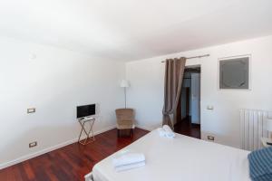 a bedroom with a white bed and a television at Wellness HM al Corso By Dimorra in Naples