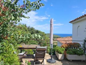 a patio with a table and a view of the ocean at ESTUDIO vistas al mar TAMARIU y bosques de BEGUR in Tamariu