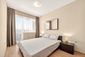 Un dormitorio con una cama y una ventana grande en Апартамент Danili нов двустаен апартамент с басейн и паркомясто в гр Бяла, en Byala 25 fotos más