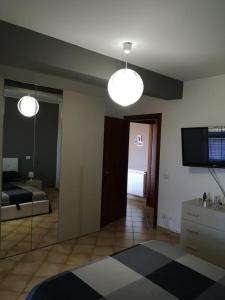 a living room with a bed and a television and two lights at Trinacria Apartment in Monforte San Giorgio Marina