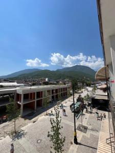 eine Gruppe von Menschen, die um ein Gebäude mit Bergen im Hintergrund herumlaufen in der Unterkunft Mountain View Apartment in the heart of city in Peja