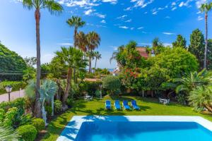 una vista aérea de un patio con piscina y palmeras en Exclusive Villa Elmessidor, en Marbella