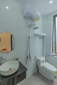 a bathroom with a sink and a toilet and a mirror at Happy Home in Da Thanh