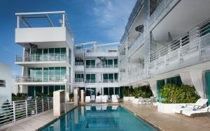 ein Gebäude mit einem Pool vor einem Gebäude in der Unterkunft SBV Luxury Ocean Hotel Suites in Miami Beach